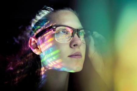 žena s brýlemi koukající na barevnou obrazovku