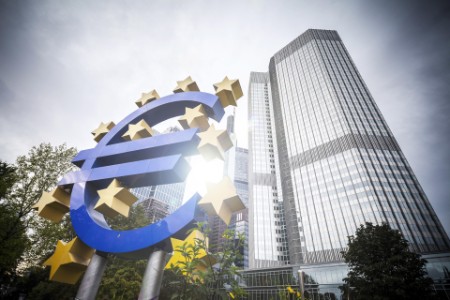 znak euro měny před mrakodrapem