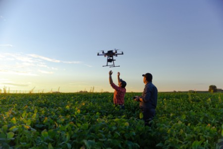farmář na poli s létajícím dronem