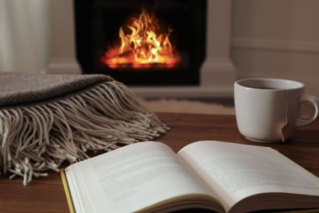open book, coffee cup and fire place