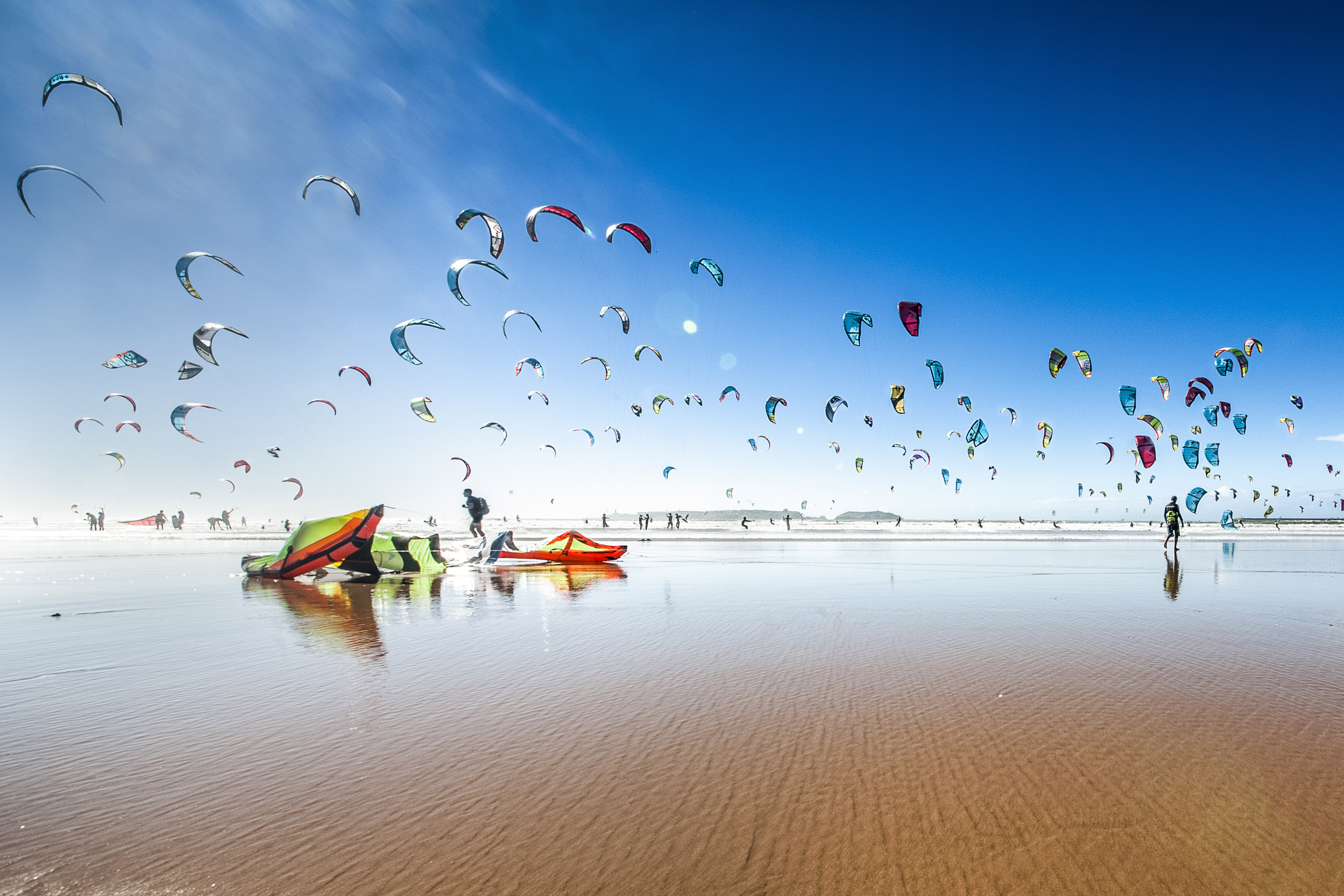 Mange paragliders på strand
