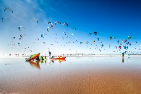 Mange paragliders på strand