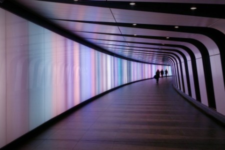 Personer går i tunnel oplyst i lilla farver