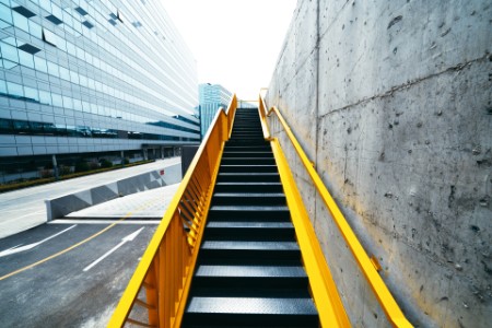 Et kig op ad en gul trappe langs en betonvæg