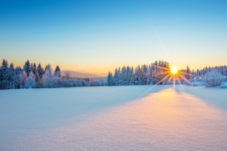 Flot solnedgang i snedækket bjerglandskab