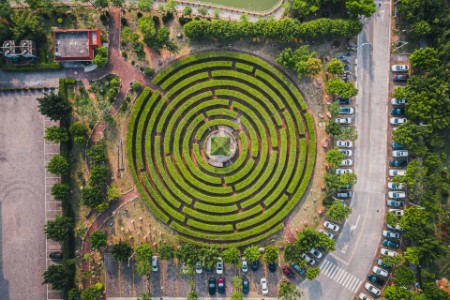 Luftfoto af en cirkulær havelabyrint og grøn pavillon