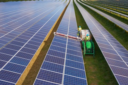 Landmand renser solceller på mark