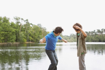 Far og søn slår smut med sten ved sø