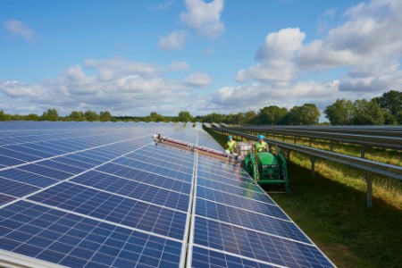 Picture of Young farmers using machinery to clean the solar panels in their farm