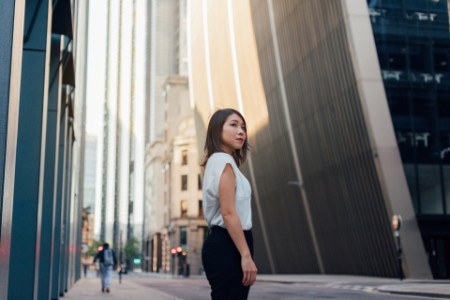 Forretningskvinde står på gaden i en storbys finansielle distrikt.