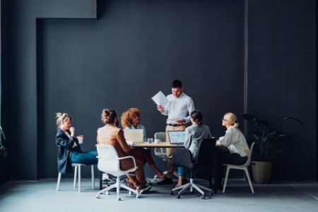 Flere personer holder møde i moderne mødelokale