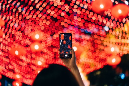 Kvinde fotograferer op mod røde lamper