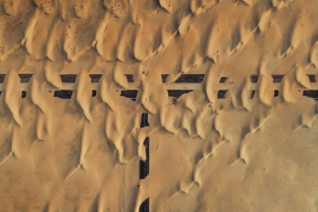 Verlassene, mit Sand bedeckte Straßenkreuzung von oben gesehen