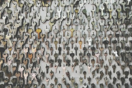 Vollbildaufnahme von Schlüsseln, die in einem Schlüsseldienst an der Wand hängen