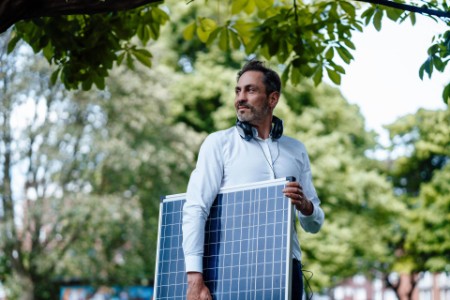 Geschäftsmann hält Solarpanel im Park