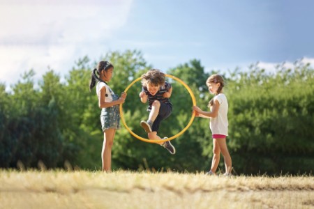 Kinder spielen mit Hula Hoop