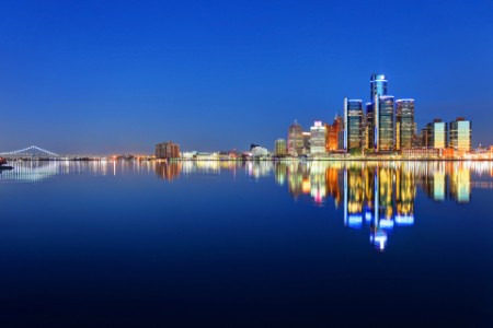 Skyline von Detroit, die sich in der Abenddämmerung auf dem Detroit River spiegelt