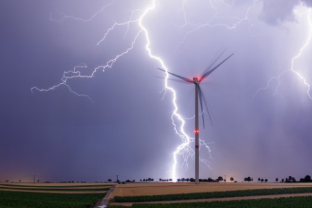 Starker Blitz hinter Windkraftanlage 
