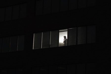 Mann steht am Fenster