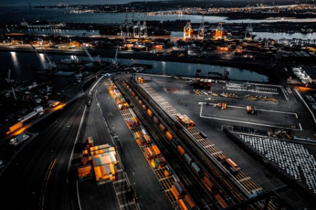 Luftaufnahme der New Jersey Shipyard mit zahlreichen Kränen, Portalen und Schiffscontainern, eingefangen in der goldenen Stunde