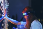 Junge Frau trägt eine Augmented-Reality-Brille und berührt den Bildschirm mit den Händen
