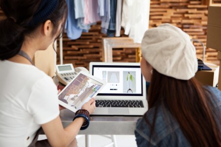Zwei Frauen kaufen Kleidung beim Online-Einkauf