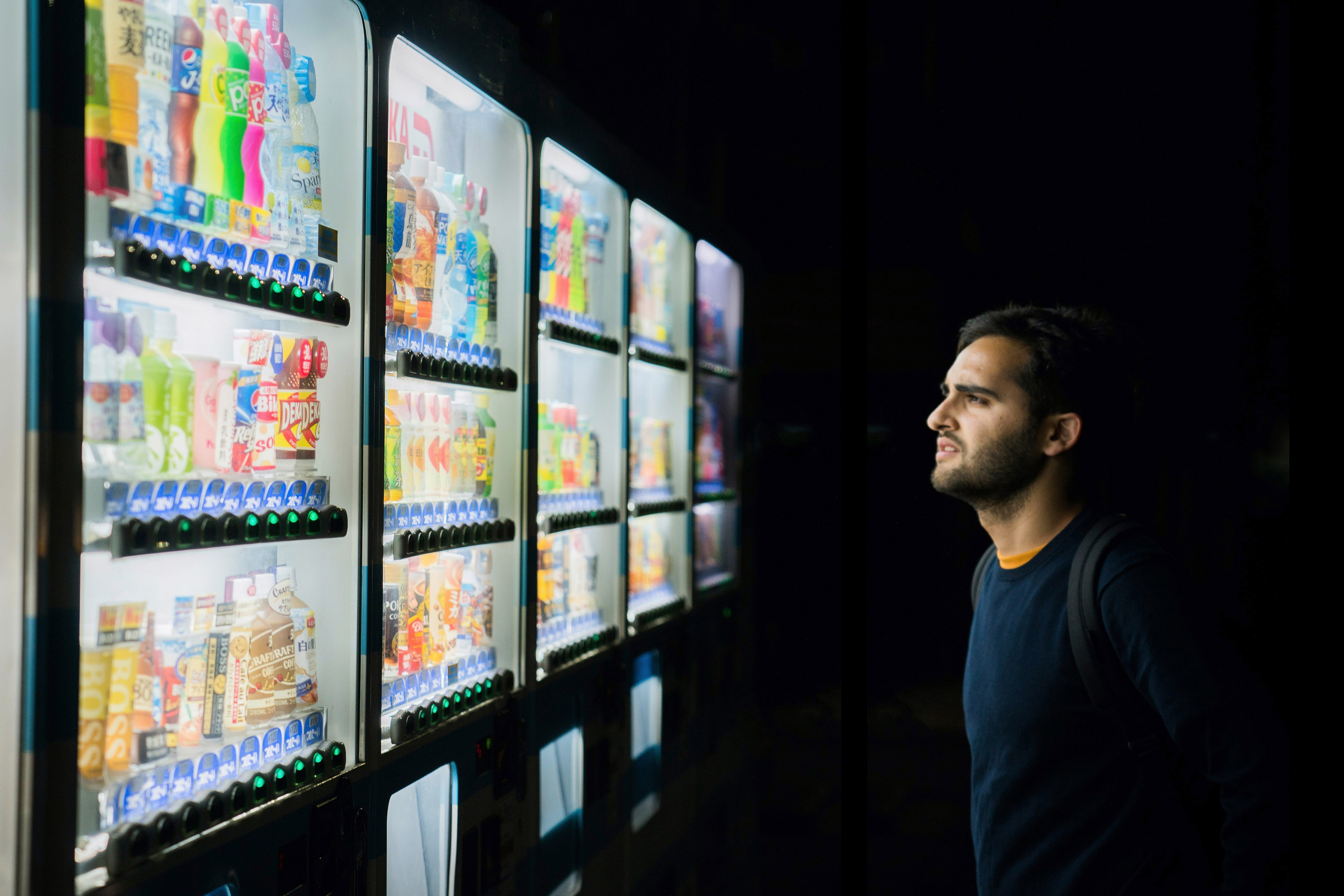 A portrait of a man looking at the vending machine