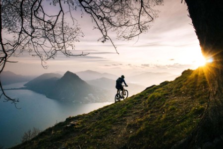 Mountainbiker überquert steilen Berghang oberhalb des Sees