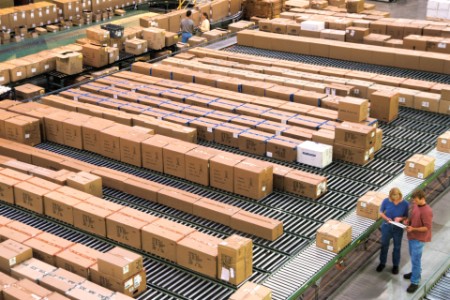 Kartons auf Foerderbaendern in industriellem Vertriebslager