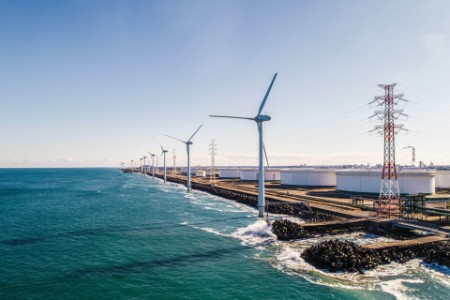 Reihe von Windkraftanlagen am Meeresufer