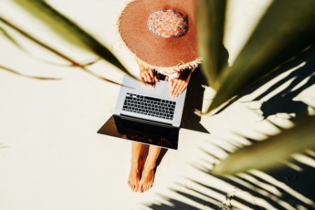 Frau mit Laptop am Strand
