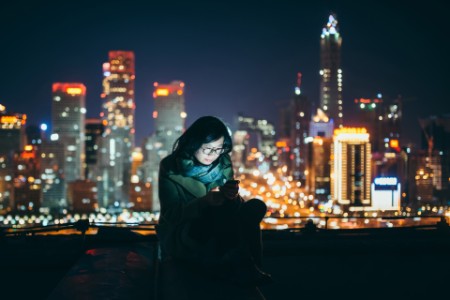 Women phone city night lights
