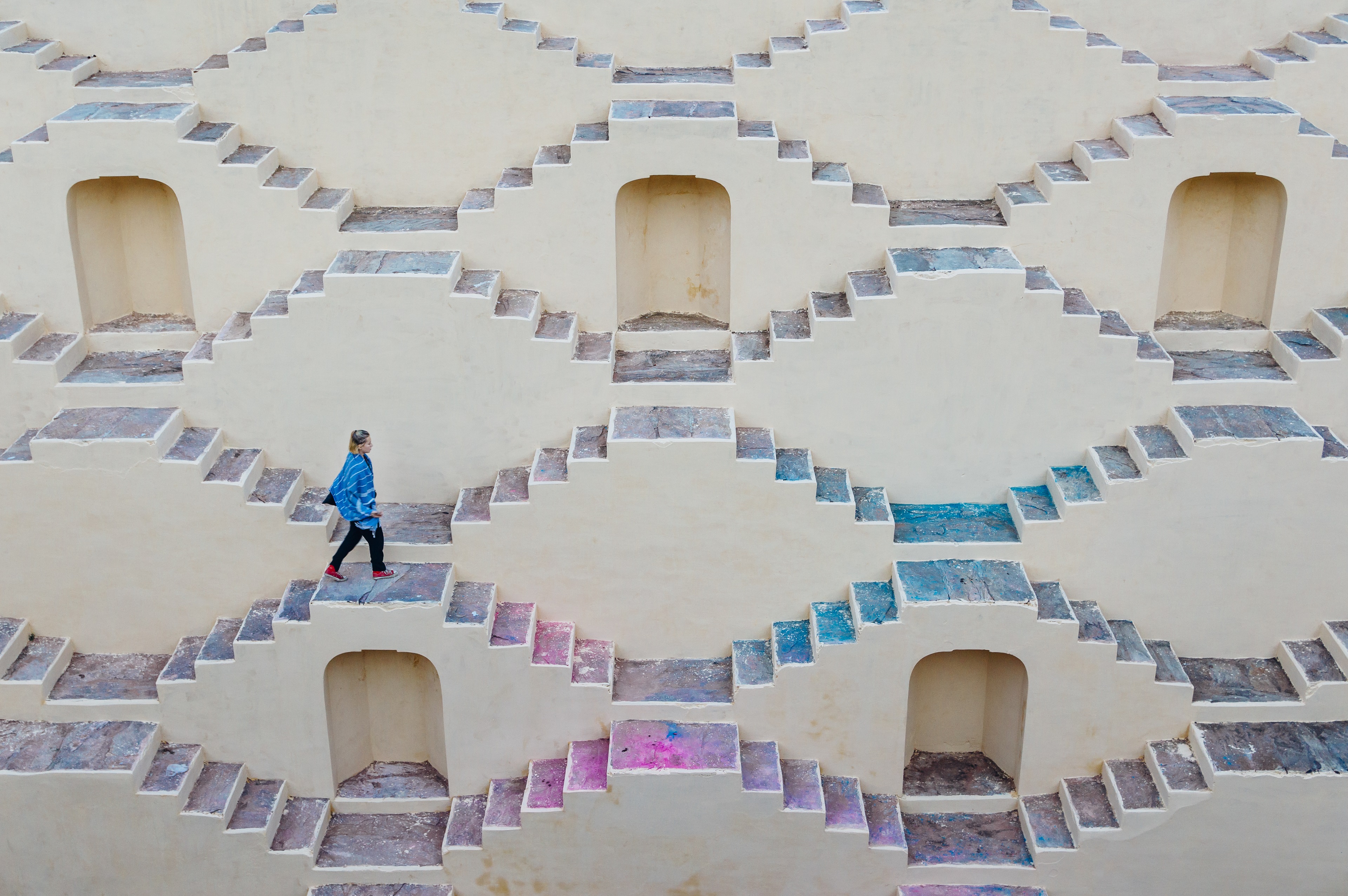 Person walking up across colourful stairs