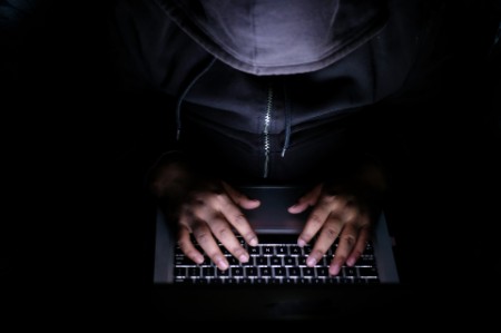 ey-man-behind-laptop-hacker