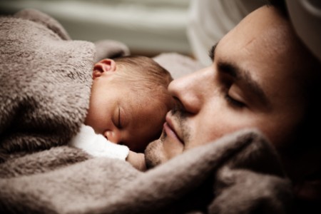 Photograph of a man holding newborn baby