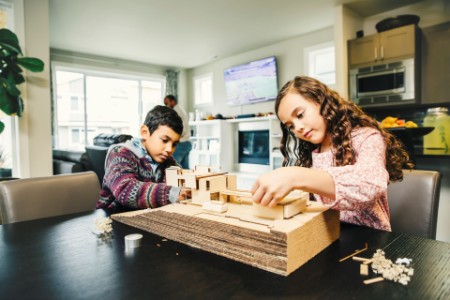 Children build a model house in their apartment
