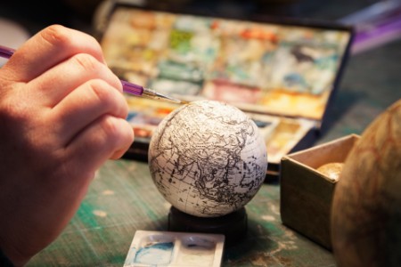 Close up of hand painting globe
