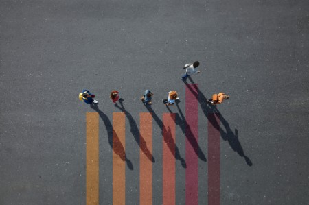 People walking on colored lines painted on asphalt