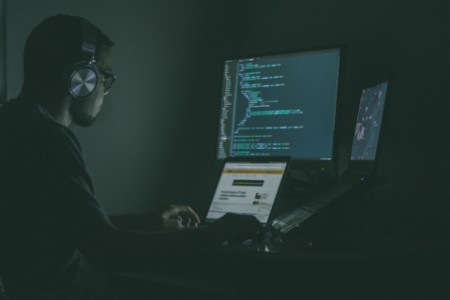 EY – homme dans le noir près d’un ordinateur
