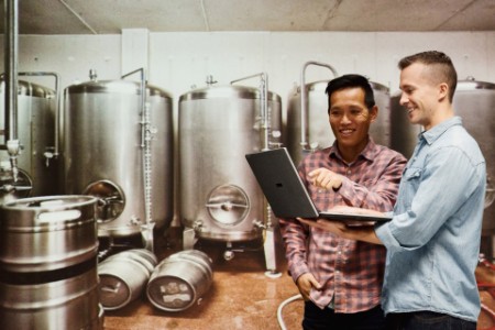 EY - Brewmasters using laptop in brewing plant