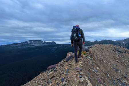 EY – Homme en randonnée le long d’une crête en haute montagne