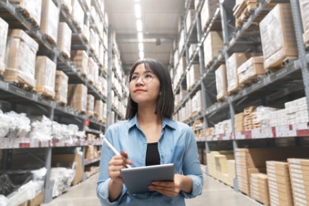 asian-woman-looking-up-stocktaking-inventory-in-warehouse