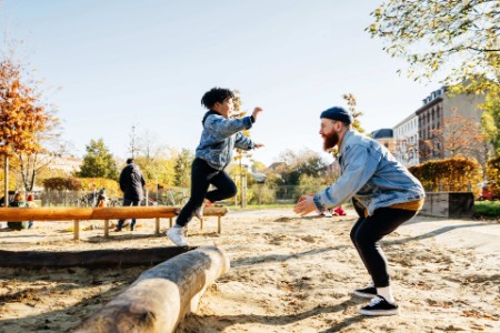 EY - Young Boy Leaping Into Father Arms In Playground