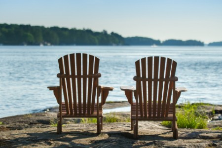 EY - Deux chaises Adirondack face à un lac au coucher du soleil