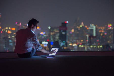 EY - Man sitting on rooftop with laptop