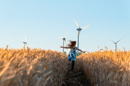 Girl is running the way to wind energy.