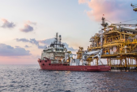 oil rig in ocean during sunset