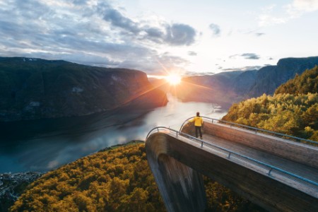 Tourist admiring the sunset over norwegian fjord, Norway