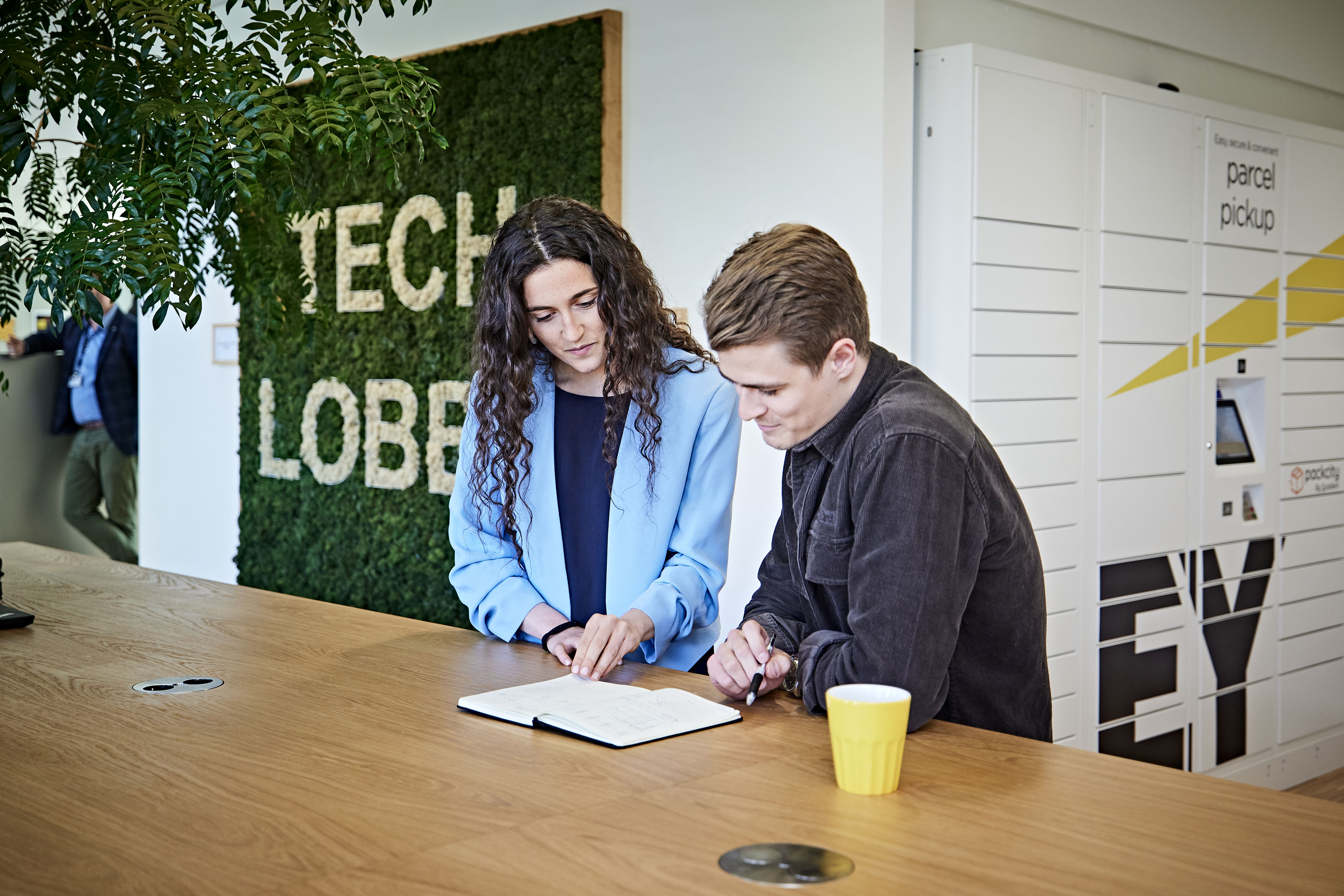 Kvinde og mand ser på dokument i tech lobby