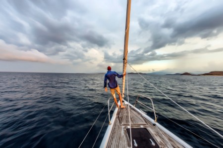 Man standing on bow of yacht